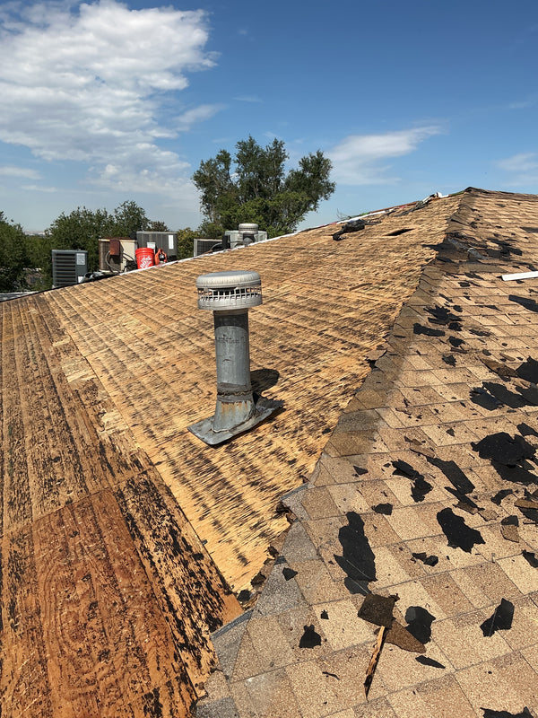 Roof with shingles and a chimney against a blue sky