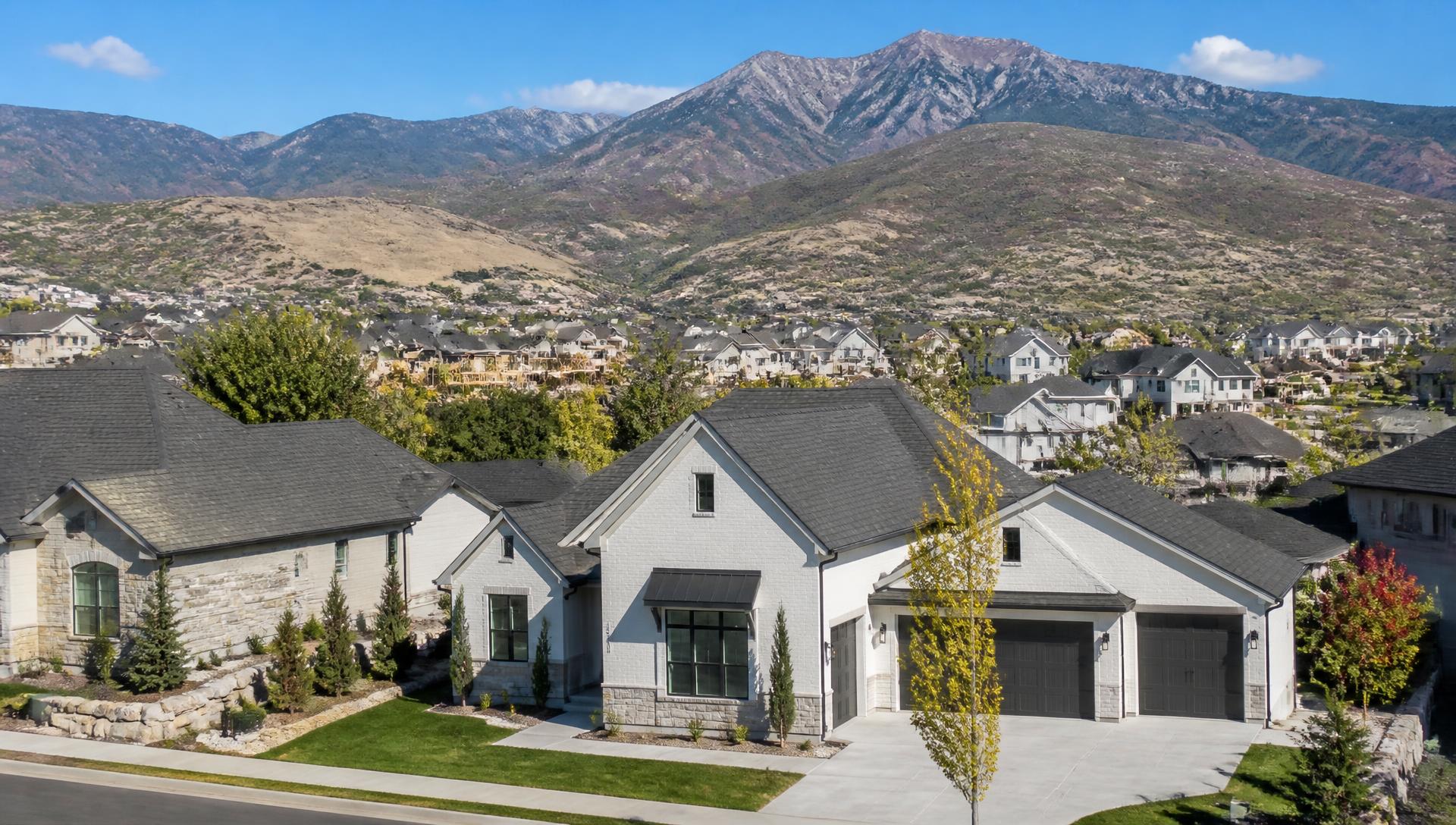Bright daytime view of a Utah neighborhood with clean rooflines and mountains behind