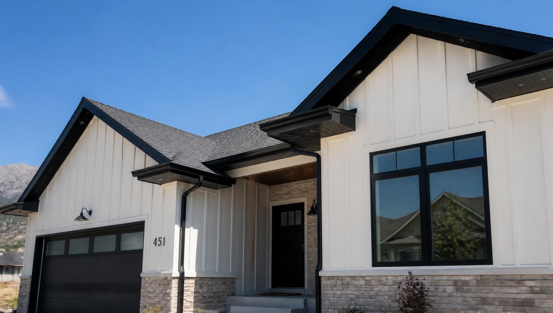 Modern Utah home exterior with clean gutters, fascia, and roofline under a bright blue sky