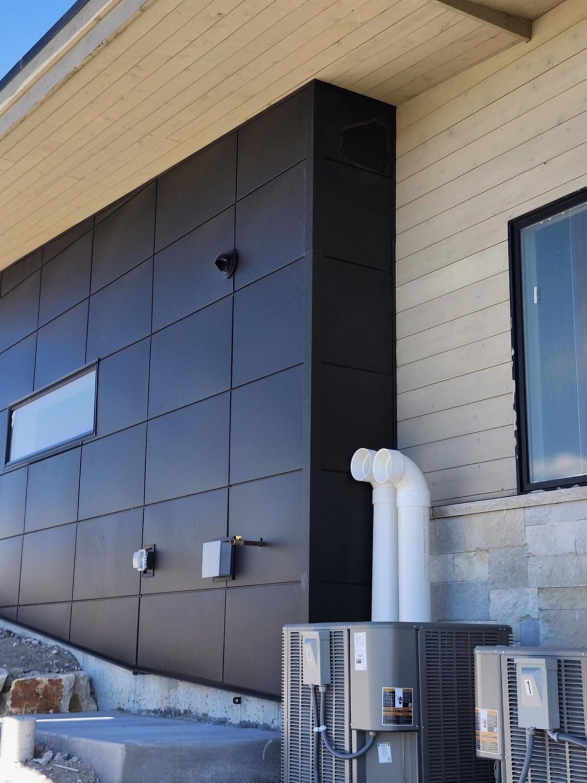 Dark metal wall panels installed on a modern building exterior