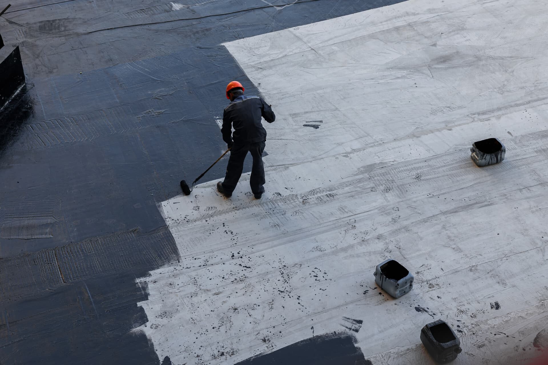 Roofing contractor inspecting seams and ponding on a flat roof