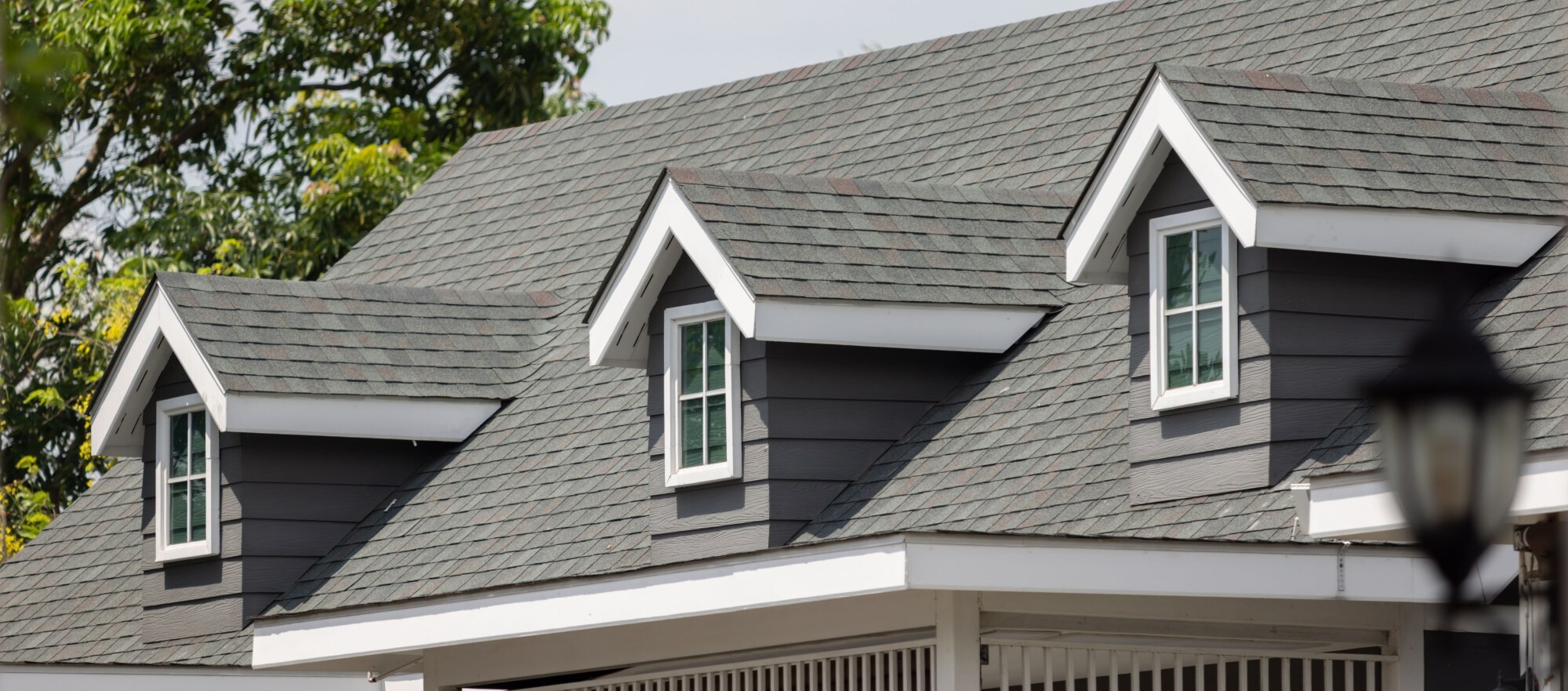 Residential home with a new architectural asphalt shingle roof on a bright day