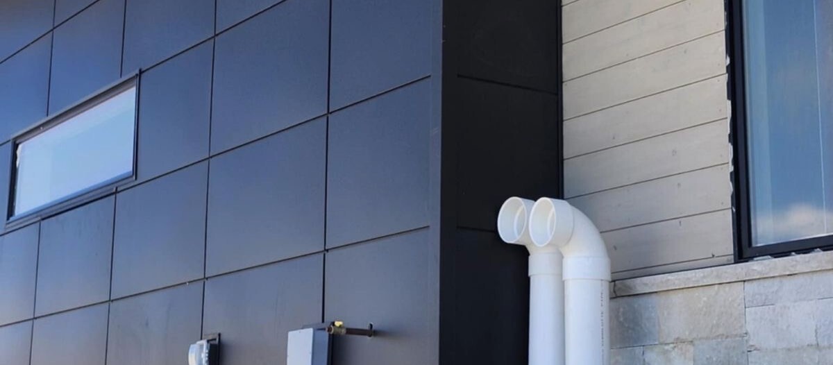 Modern building exterior with clean metal wall panels under a bright sky